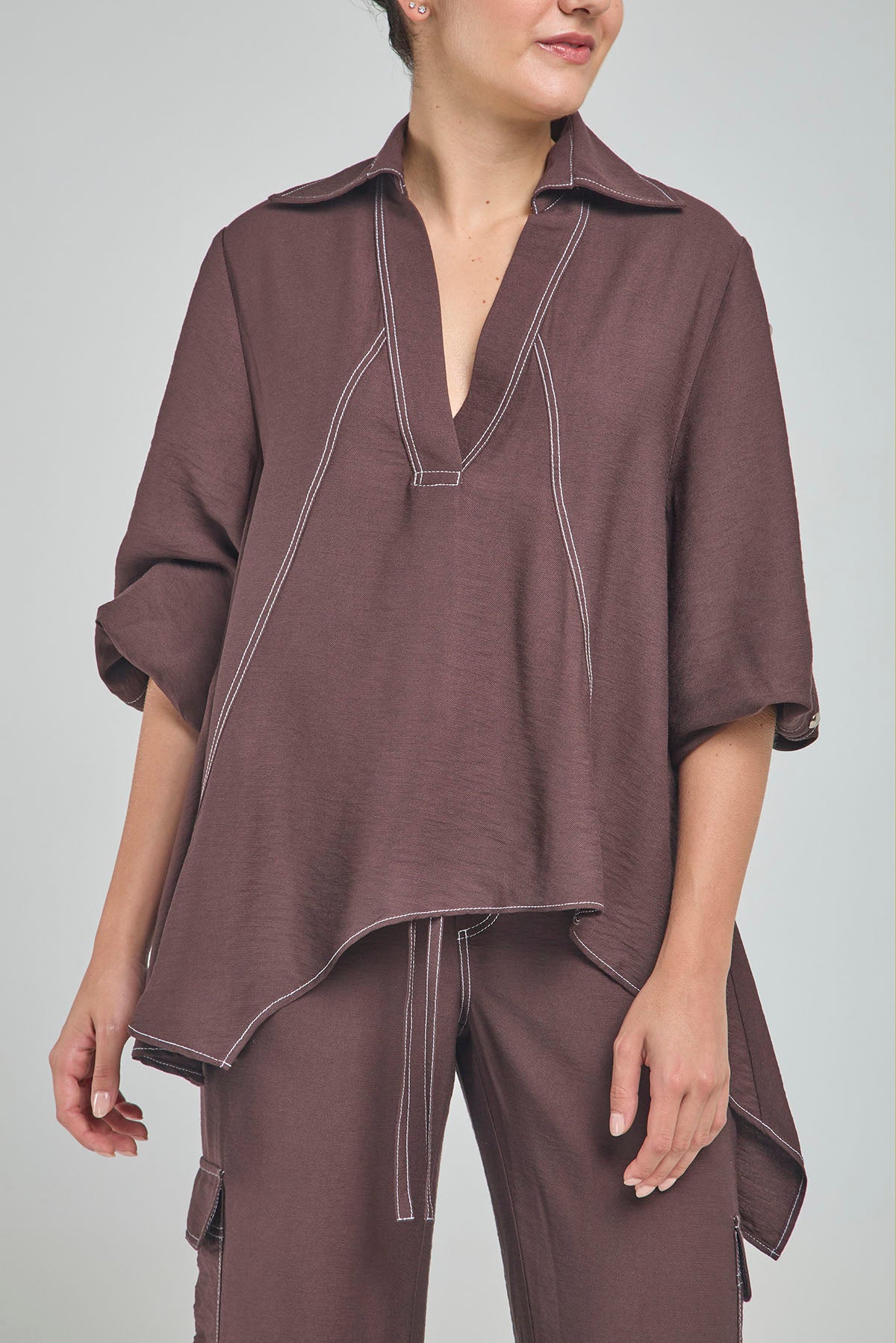 BLUSA PERTINA INTERNA CORTE DIAGONAL FRONTAL CON TACHES EN MANGA