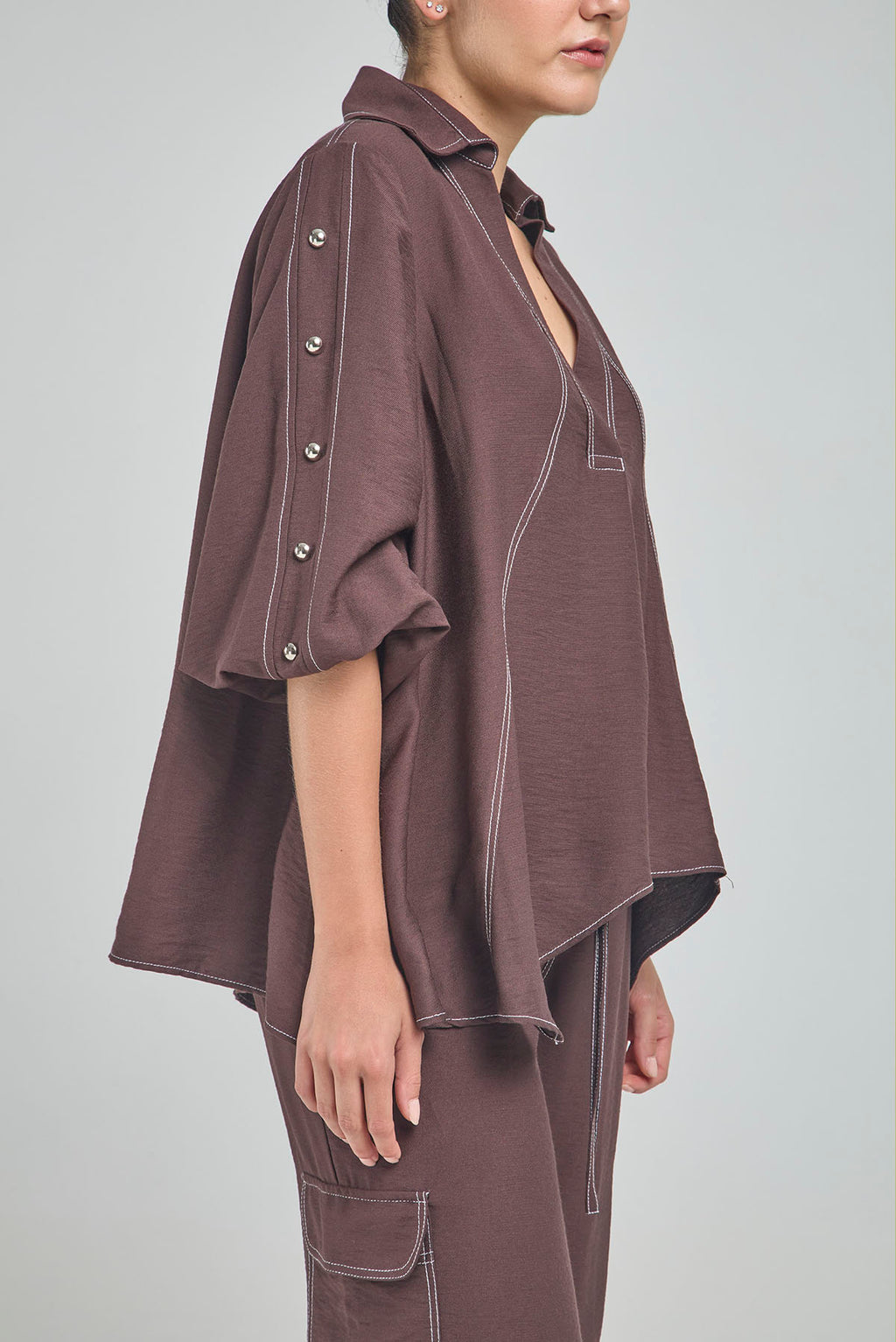 BLUSA PERTINA INTERNA CORTE DIAGONAL FRONTAL CON TACHES EN MANGA
