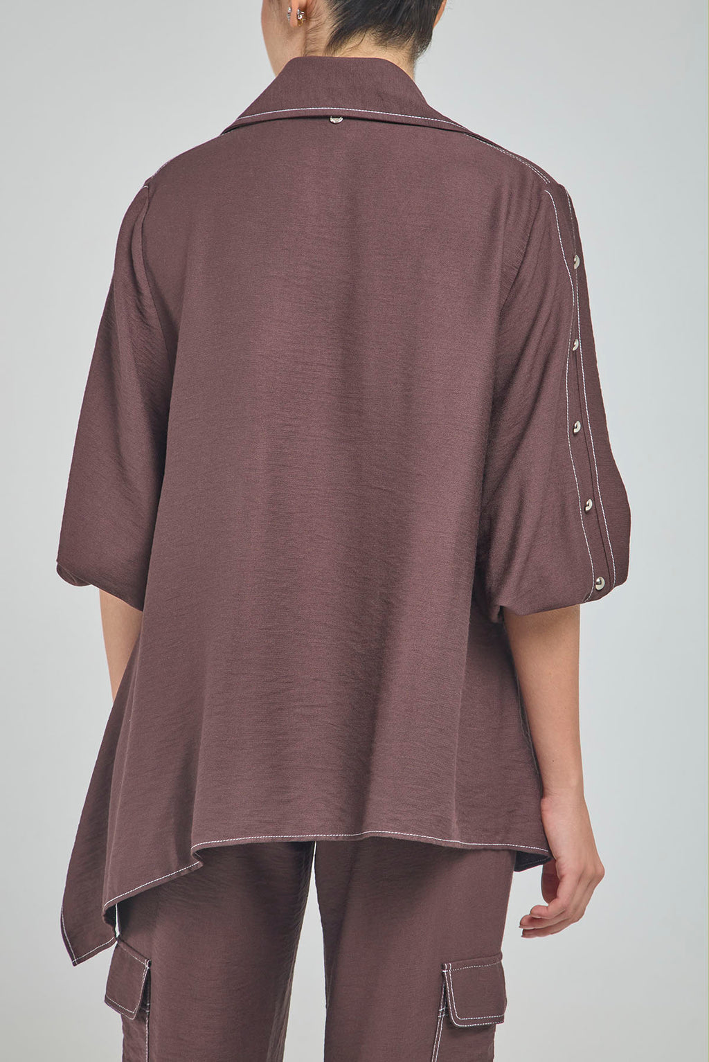 BLUSA PERTINA INTERNA CORTE DIAGONAL FRONTAL CON TACHES EN MANGA