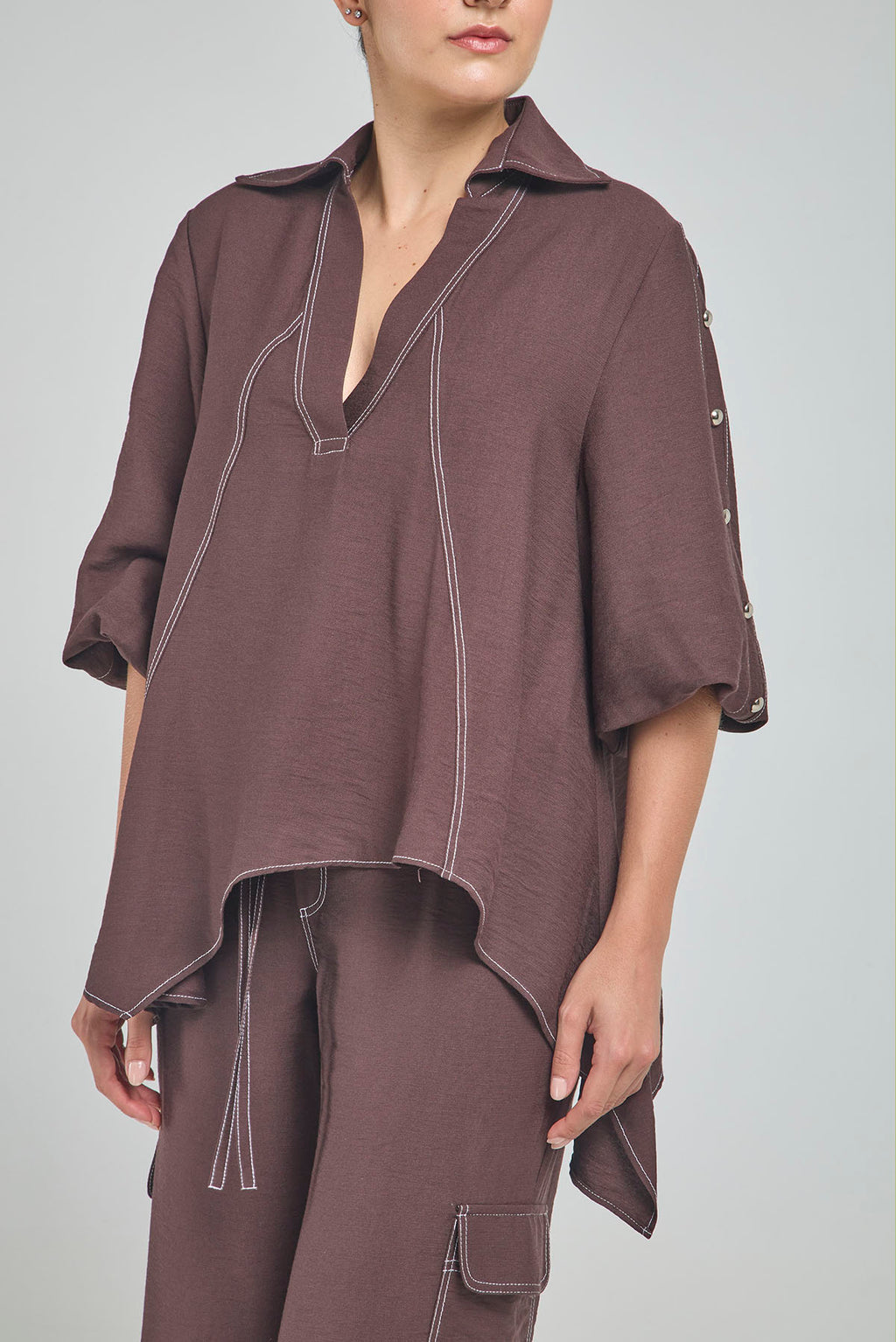 BLUSA PERTINA INTERNA CORTE DIAGONAL FRONTAL CON TACHES EN MANGA