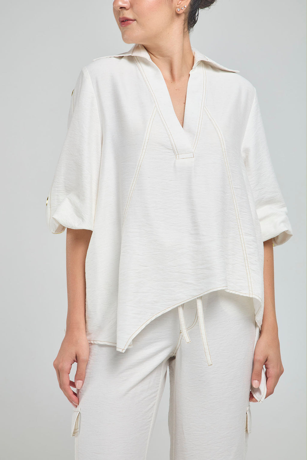 BLUSA PERTINA INTERNA CORTE DIAGONAL FRONTAL CON TACHES EN MANGA