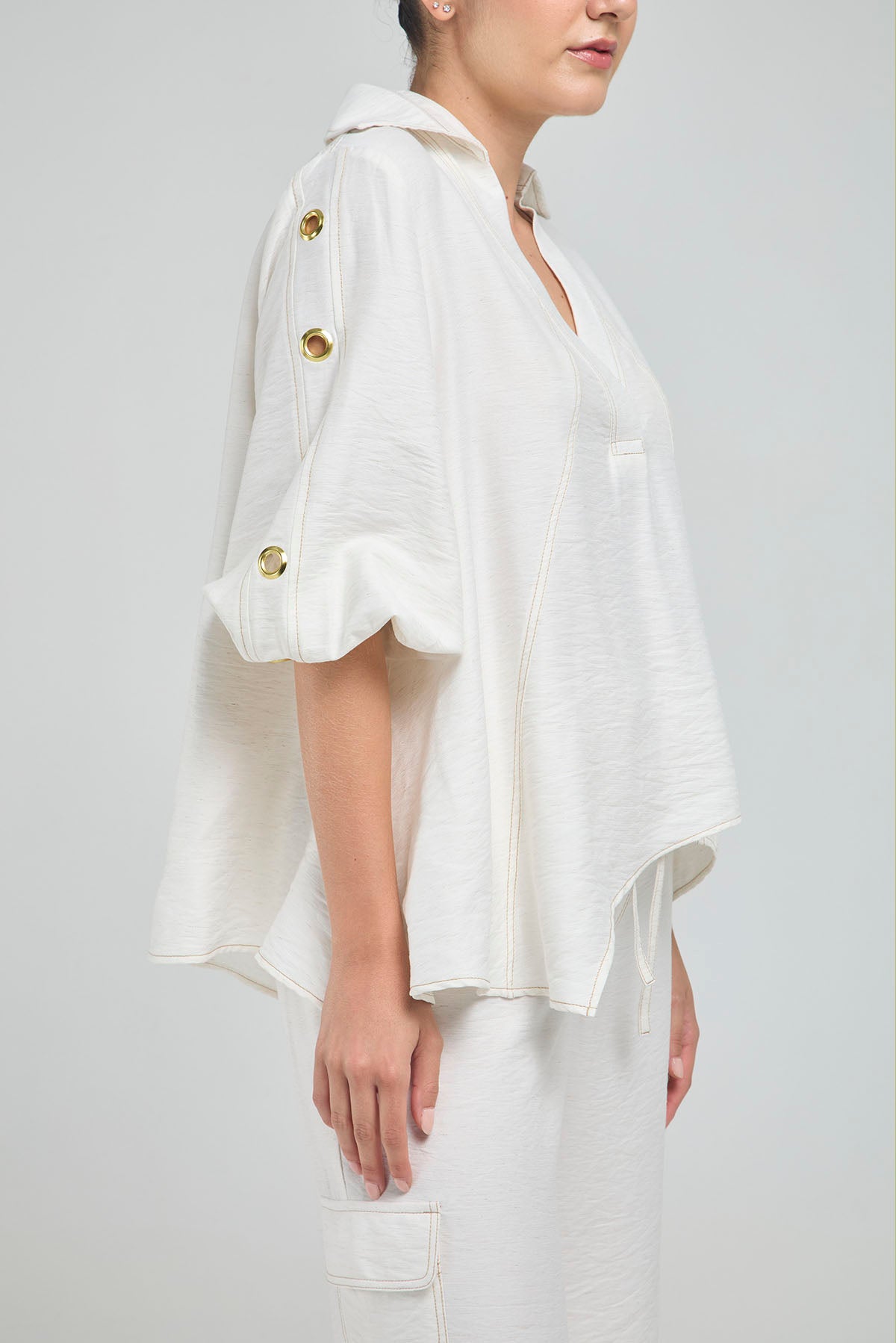 BLUSA PERTINA INTERNA CORTE DIAGONAL FRONTAL CON TACHES EN MANGA