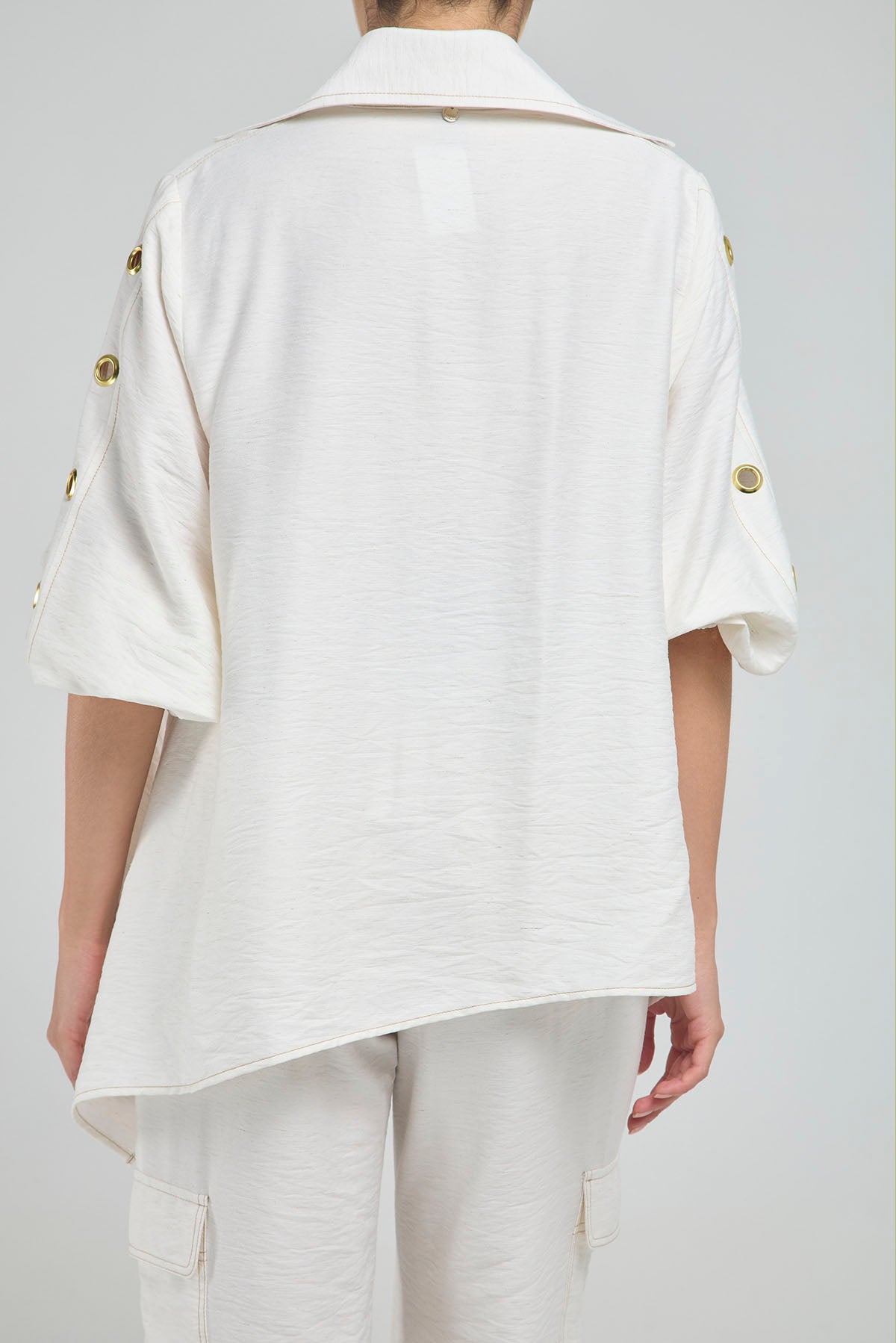 BLUSA PERTINA INTERNA CORTE DIAGONAL FRONTAL CON TACHES EN MANGA