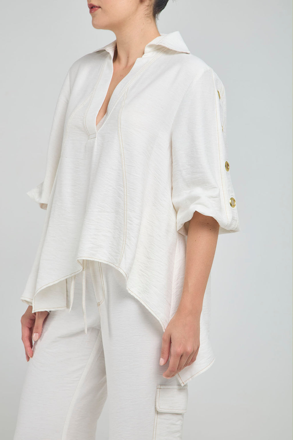 BLUSA PERTINA INTERNA CORTE DIAGONAL FRONTAL CON TACHES EN MANGA